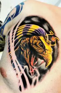 Farbiges Horus-Tattoo mit Falkenkopf und leuchtenden Gelb-, Orange- und Schwarztönen